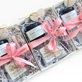 Gift set with body creme, eye pillow  and lip balm wrapped in pink ribbons in a box on a white background
