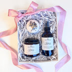 Gift set including a candle, bath bomb and spray in a box with pink ribbon.